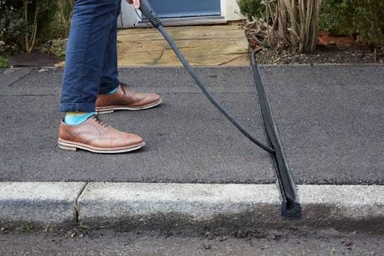 Bündige Kabelrinne im Gehweg mit eingelegtem Ladekabel.